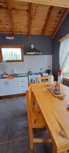 a kitchen with a wooden table in a room at cabaña La Ufu 2 in Golondrinas