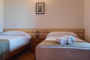 two beds in a room with towels on them at Finca Roja Formentera in Sant Francesc Xavier