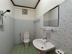a bathroom with a sink and a toilet and a mirror at ksana guesthouse in Luang Prabang