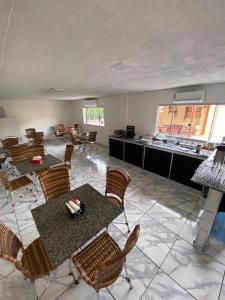 a room with tables and chairs and a kitchen at HOTEL ALAMEDA in Várzea Grande