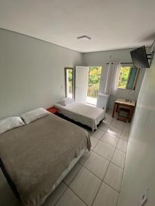 - une chambre avec 2 lits et une table dans l'établissement HOTEL ALAMEDA, à Várzea Grande