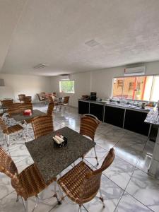 a room with a table and chairs and a kitchen at HOTEL ALAMEDA in Várzea Grande