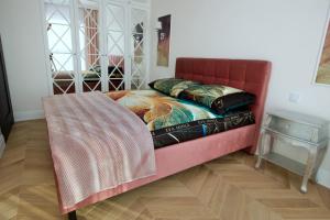 a bed in a room with a red couch at Apartament BOTANIQ #free parking in Bydgoszcz