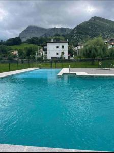 a large pool of blue water with mountains in the background at Casa en la montaña con piscina de temporada in Arredondo