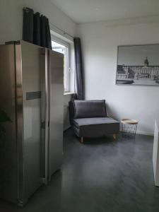 sala de estar con sofá y silla en Moderne 2 Zimmerwohnung/ Eggenstein/nähe KIT Nord, en Eggenstein-Leopoldshafen