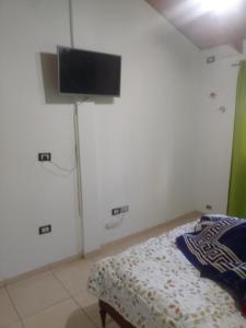 a bedroom with a bed and a flat screen tv at Duplex Dorrego- Guaymallén in Guaymallen