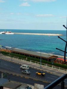 uma auto-estrada com carros e um edifício junto ao oceano em سيدي بشر السرايا em Alexandria