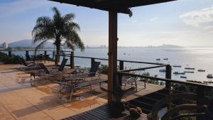 a balcony with chairs and a view of the water at Pousada Vila de Monaco in Penha