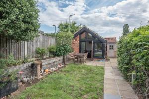 a small garden with a glass extension to a brick house at Long Barn, Wrentham in Beccles