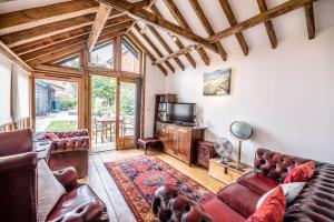 uma sala de estar com um sofá e uma televisão em Long Barn, Wrentham em Beccles