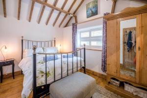 a bedroom with a metal bed and a window at Long Barn, Wrentham in Beccles