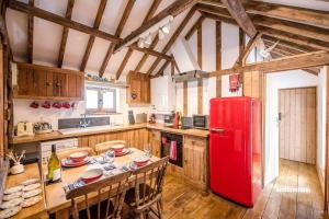 um frigorífico vermelho numa cozinha com uma mesa em Long Barn, Wrentham em Beccles
