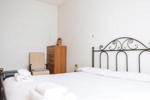 um quarto com 2 camas com lençóis brancos e uma cómoda em Accogliente APT a 750m da Stazione FS e metro em Sesto San Giovanni