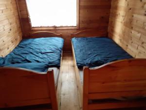 2 łóżka w małym pokoju z oknem w obiekcie Sommerhaus am See w Ślesinie