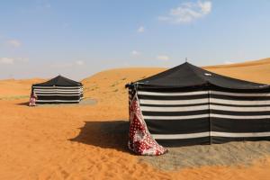dos tiendas sentadas en la arena en el desierto en Desert Private Camps - Private Bedouin Tent, en Shāhiq