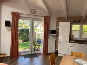 a kitchen with a table and a clock on the wall at Moderne Ferienwohnung mit Kamin u Garten im EG 100qm Nähe Weser und Golfplatz in Achim
