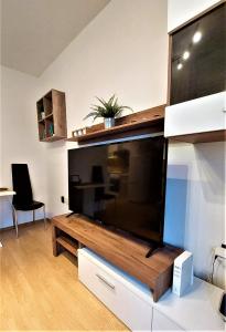 TV de pantalla plana grande en la sala de estar. en "Like a Home" Apartment, en Bratislava