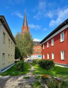 a church with a steeple in the background with two buildings at Apartment in City Center in Tartu