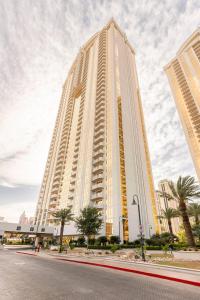 un grand bâtiment blanc avec des palmiers devant lui dans l'établissement MGM Signature Towers by FantasticStay, à Las Vegas