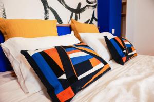 a bed with three pillows on top of it at Maison Arcades chambre 2 in Verdun-sur-Garonne