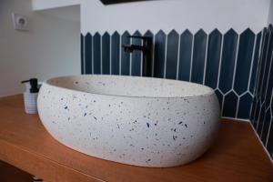 a bath tub sitting on a wooden counter in a bathroom at Maison Arcades chambre 2 in Verdun-sur-Garonne