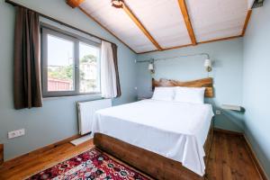 een slaapkamer met een bed, een raam en een tapijt bij Stunning Sea View Loft 5 min to Park in Kuzguncuk in Istanbul