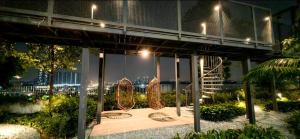 un bâtiment avec deux planches à roulettes assises sur un banc la nuit dans l'établissement TRION KL by JRLodge Homestay, à Kuala Lumpur