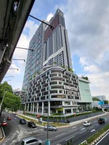 ein hohes Gebäude mit Autos auf einer Stadtstraße in der Unterkunft TRION KL by JRLodge Homestay in Kuala Lumpur