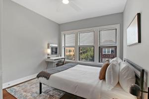 Un dormitorio con una cama, un escritorio y ventanas. en 3BR Spacious Apartment with In-Unit Laundry - Kedzie 3F, en Chicago