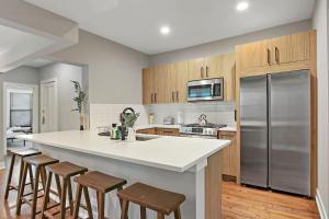 una cucina con ampia isola bianca con sgabelli da bar di 3BR Spacious Apartment with In-Unit Laundry - Kedzie 3F a Chicago Altre 19 foto