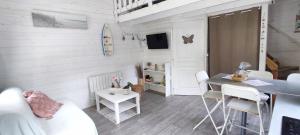 ein Wohnzimmer mit einem Tisch und einem Esszimmer in der Unterkunft Chalet cosy, plages à pieds. Morbihan. in Plouhinec