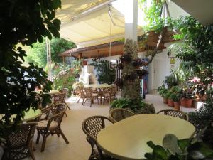 an outdoor patio with tables and chairs and plants at Family Hotel Sofi in Sozopol