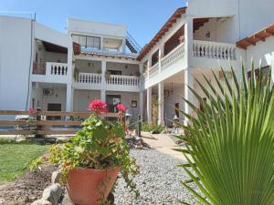 ein großes weißes Haus mit Pflanzen davor in der Unterkunft Hotel Maria Cafayate in San Carlos