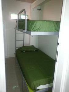Habitación pequeña con 2 literas y sábanas verdes en Appartamento Maspalomas Vista Golf con piscina, en Maspalomas