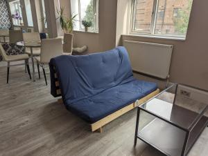 ein blaues Sofa in einem Zimmer mit einem Tisch in der Unterkunft Flat In Camden Town in London
