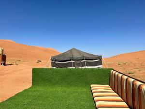 un banc devant une tente dans le désert dans l'établissement Desert Private Camps - Private Bedouin Tent, à Shāhiq