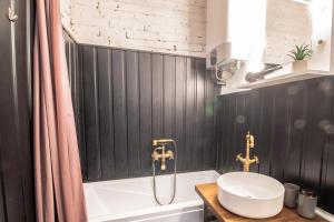 een badkamer met een wastafel en een ligbad bij Corvin Loft in Boedapest