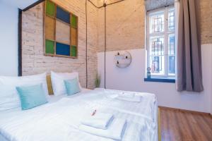 een slaapkamer met een groot wit bed met een raam bij Corvin Loft in Boedapest +10 foto's