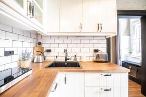 een keuken met witte kasten en een spoelbak bij Corvin Loft in Boedapest