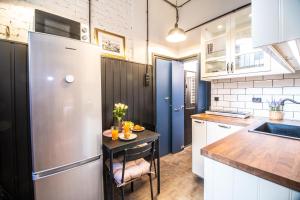 een keuken met een kleine tafel en een koelkast bij Corvin Loft in Boedapest