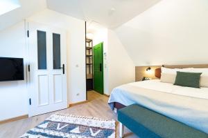 um quarto com uma cama branca e uma porta verde em Czakó Bed&Breakfast em Budapeste
