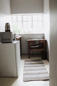 uma cozinha com um lavatório, um frigorífico e uma mesa em Ruigtevallei Lodge em Gariepdam
