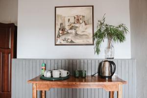 uma mesa de madeira com um bule de chá e uma planta sobre ele em Ruigtevallei Lodge em Gariepdam
