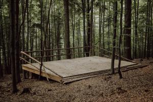 a wooden bed in the middle of a forest at WisiLas Nad Sercowym Potokiem in Rabka