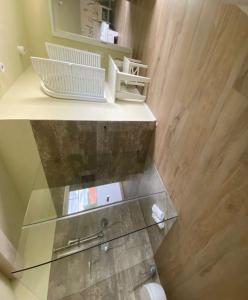 - une étagère en verre dans la salle de bains pourvue de toilettes dans l'établissement Barrierefreies Ferienhaus in Altwarp mit Sauna, Kamin und Wasserblick, à Altwarp