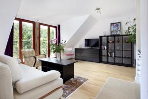 a living room with a white couch and a table at Horizon Forest moj-sopot pl in Sopot
