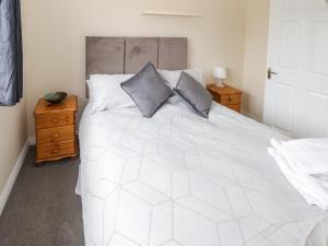 a bedroom with a large white bed with two pillows at 39 Quignalecka in Ballina