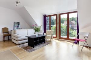 a living room with a white couch and a table at Horizon Forest moj-sopot pl in Sopot