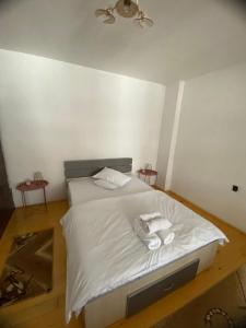um quarto com uma cama branca com duas toalhas em Casa Eroilor em Curtea de Argeş