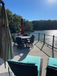 a deck with a table and chairs and an umbrella at Cozy 4br Lake Lanier GA Waterfront- Great Location in Gainesville